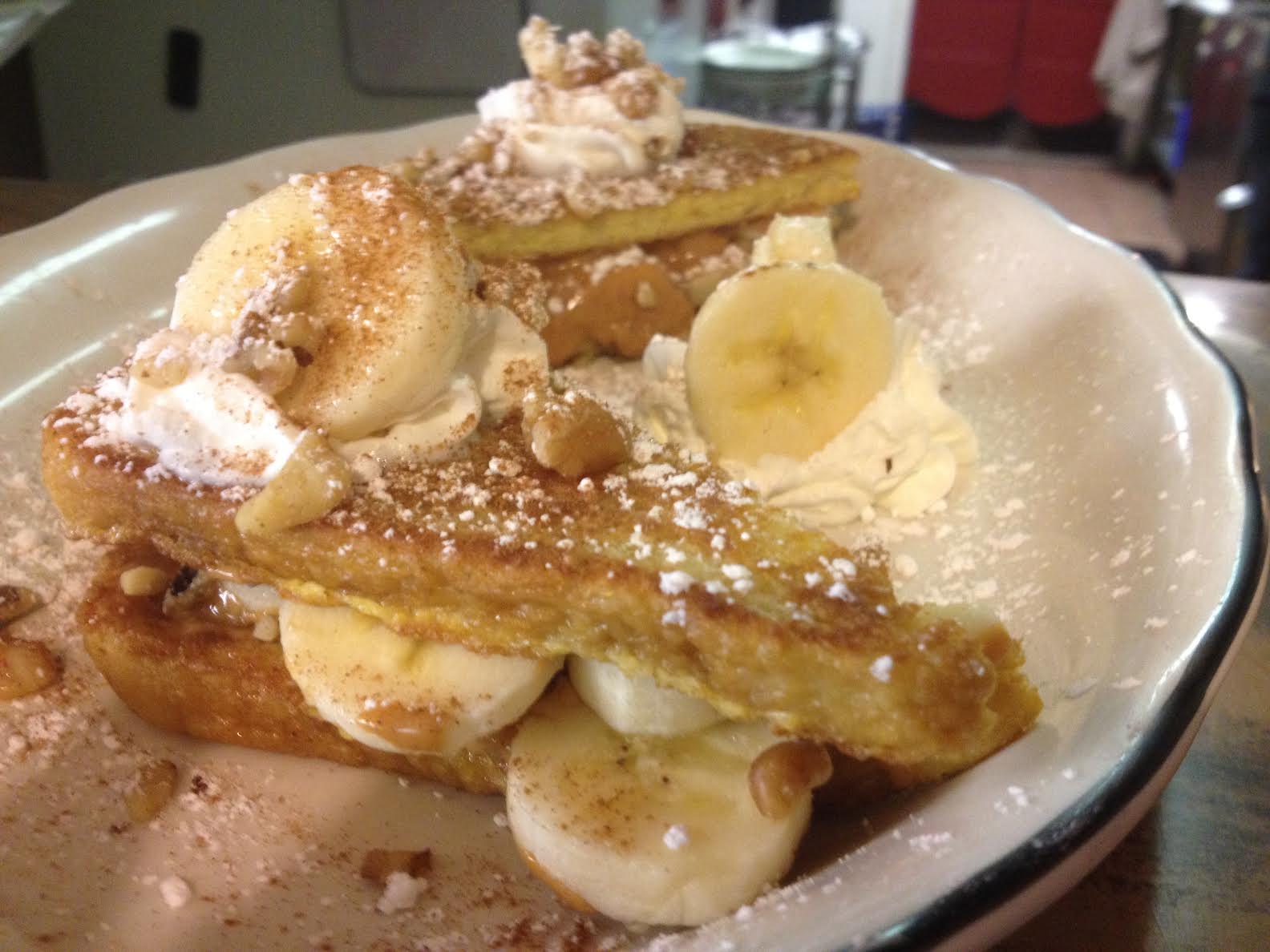 French toast topped with banana slices and whipped cream
